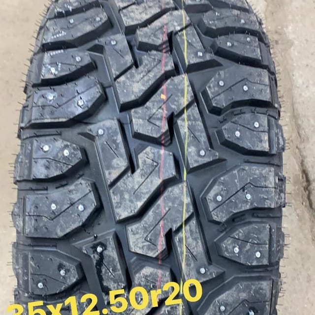 Gros plan d’une bande de roulement 35x12.50R20 garnie de clous.